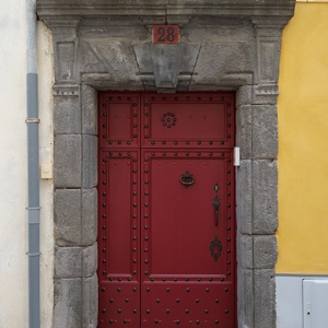 Belle porte en bois cloutée encadré de pierres de taille sur un mur jaune - France  - collection de photos clin d'oeil, catégorie portes